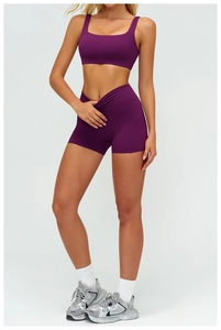 Dettaglio del set yoga viola scuro con pantaloncini a vita alta e reggiseno sportivo