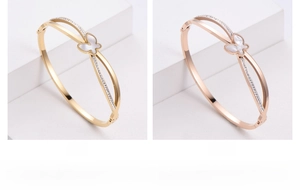 Detail of gold and rose gold butterfly bangles with shell inlay and pavé rhinestones