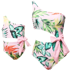 Detail of one-shoulder cut-out swimsuit with tropical print and pink bow decoration