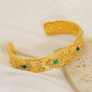 Detail of gold hammered texture cuff with malachite evil eye and sparkling zircon stones