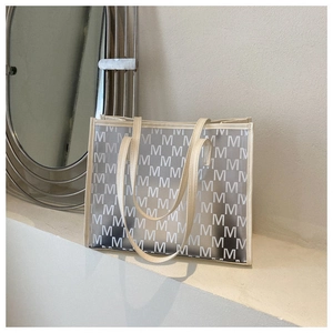 Detail view of large capacity PVC tote bag with M-letter print and beige trim