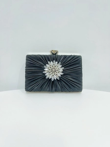 Detailansicht einer schwarzen Seiden-Abendtasche mit einem großen floralen Kristallschmuck