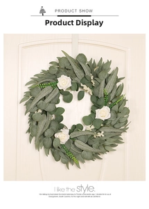 Detail of eucalyptus and white rose wreath hanging on a minimalist wooden door