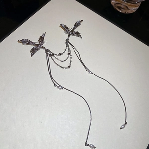 Detail of phoenix bird brooch with pearl tassels and triple-layer metal chains in gunmetal