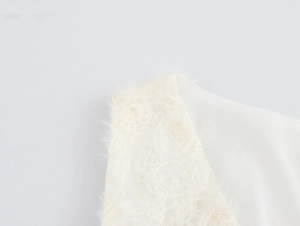 Close-up of white dress shoulder featuring exquisite lace fabric and fine texture details