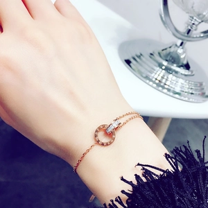 Detail of rose gold double interlocking rings with Roman numerals and pavé cubic zirconia