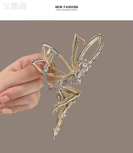 Detailed view of a gold fairy claw clip with sparkling rhinestones held in hand