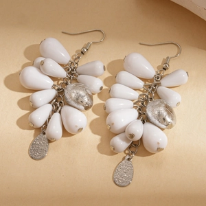 Detailed close-up of acrylic teardrop pendant earrings with silver hook accents