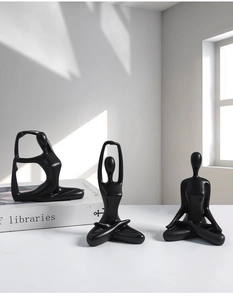 Macro detail of minimalist black ceramic yoga figurines with artistic shadows