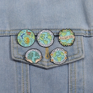 Detailed view of eco-friendly enamel pins with nature slogans on denim jacket