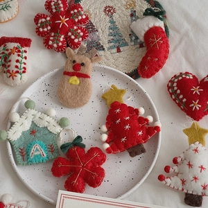 Detailed macro of handmade wool felt Christmas ornaments including reindeer and snowflake motifs