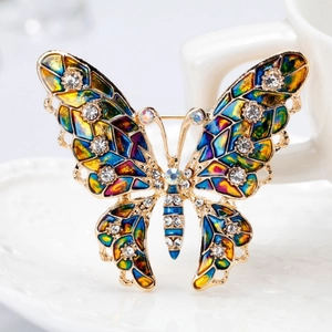Elegant colorful enamel butterfly brooch with crystals on white porcelain background
