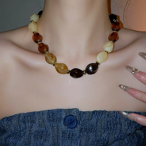 Fashionable close-up of beaded necklace with amber resin beads and gold metal spacers
