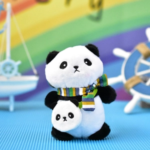 Close-up of cute panda plush keychain with striped scarf and mini panda bag accessory