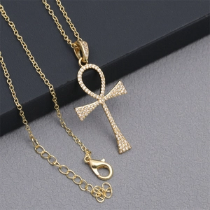 Detailed macro view of golden Ankh cross pendant with micro-inlaid clear zircon gemstones