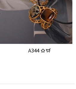 Macro shot of gold-plated chain rings with square amber and dalmatian stone inlays