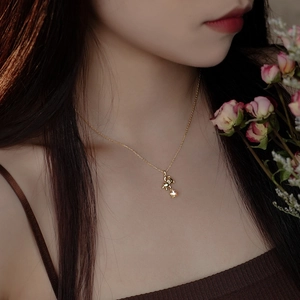S925 sterling silver bear and star necklace worn by a woman with an elegant gold finish