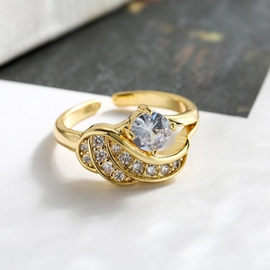 Macro shot of gold plated wing ring featuring a round zircon and pave setting
