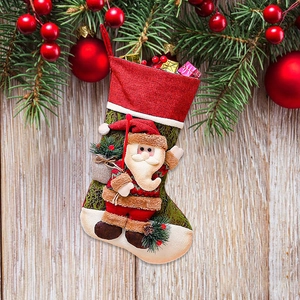 Calza di Natale con Babbo Natale 3D e scatole regalo su sfondo festivo decorato