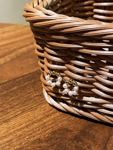 925 silver pearl stud earrings in gold circle design on a rustic wicker basket