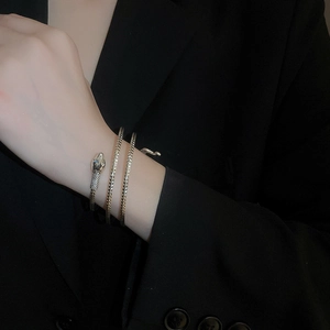 Detailed view of silver snake bangle with engraved scale texture on female arm