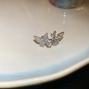 Macro view of silver butterfly ear cuff with sparkling rhinestones and hollow design