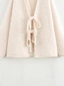 Detail of soft cream sherpa cardigan fleece texture with front ribbon tie closure