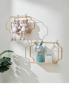 Close-up of minimalist gold metal wave shelf with wooden base for wall decor