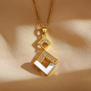 Macro detail of gold geometric necklace featuring layered diamonds and white enamel