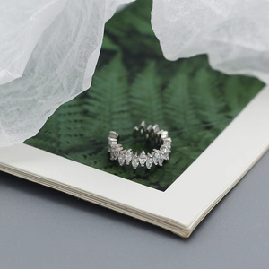 Detailed view of silver cuff ring with marquise-cut zircons on a nature-themed background