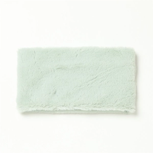 Close-up of soft mint green faux rabbit fur texture on a warm winter neck warmer scarf