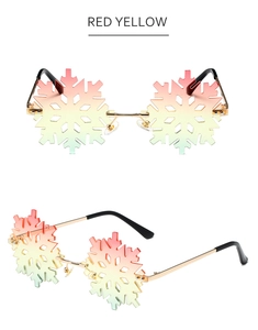 Detail view of snowflake-shaped sunglasses with red-yellow gradient lenses and gold frame