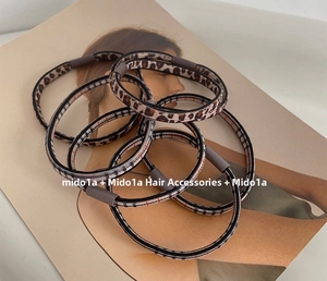 Close-up of leopard pattern seamless hair ties with gray matte buckle on a magazine