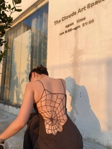 Detailed view of backless maxi dress featuring intricate spider web knit cut-outs