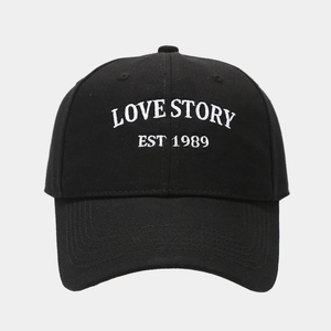 Detailed close-up of white LOVE STORY 3D embroidery on a black cotton baseball cap