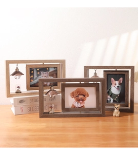 Close-up of rotating wooden photo frame with preserved flower and warm light bulb
