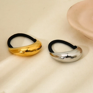 Minimalist gold and silver geometric curved metal hair ties with elastic bands on fabric