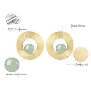 Detailed macro view of S925 silver gold plated earrings with aventurine stones
