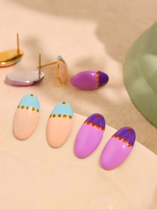 Macro shot of colorful enamel oval stud earrings with polka dots on a ceramic plate
