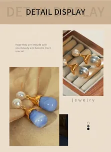 Detailed macro view of waterdrop resin earrings with gold accents in blue and amber tones