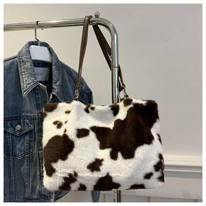 Macro detail of plush cow print tote bag with soft faux fur texture and brown straps