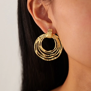 Detailed close-up of gold layered hoop earrings with vintage twisted spiral texture
