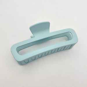 Close-up of light blue matte square hair claw clip with cutout design on white background