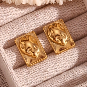Macro view of 18K gold-plated irregular rectangular earrings on beige jewelry box