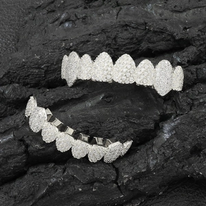Detail of silver-plated hip hop grillz set with sparkling cubic zirconia on a dark rock