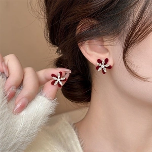 Elegant velvet snowflake flower earrings with pearls on model in cozy winter scene