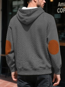 Détail du sweat à capuche gris pour homme avec texture jacquard et patchs de coude oranges