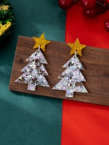 Close-up of sparkling Christmas tree earrings with sequins and gold star studs