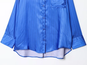 Detailed macro view of royal blue striped satin shirt buttons and smooth texture