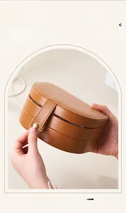 Detailed view of the metal snap closure on a multi-layer brown leather jewelry box